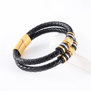 Men's double-layered braided leather bracelet with gold magnetic clasp on marble
