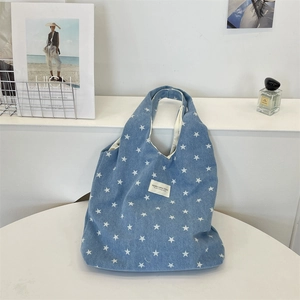 Detailansicht der dunkelblauen Denim-Einkaufstasche mit weißen Sternmustern und Markenetikett