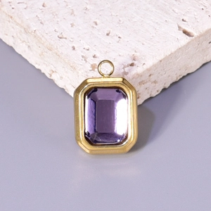 Close-up of golden rectangular pendant with emerald-cut purple gemstone on stone base