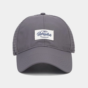 Detail of dark grey baseball cap featuring mesh panels and vintage embroidered logo patch