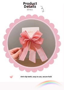 Detailed view of pink ribbon bow hair clip with dotted edges on display card