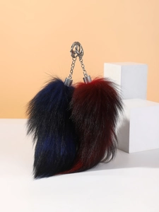 Close-up of fluffy dark blue and burgundy fur tail keychains with silver metal clips