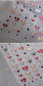 Macro view of 3D heart nail stickers featuring glitter texture and embossed gold details