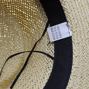 Detailed view of straw sun hat interior with 100% paper texture and adjustable sweatband