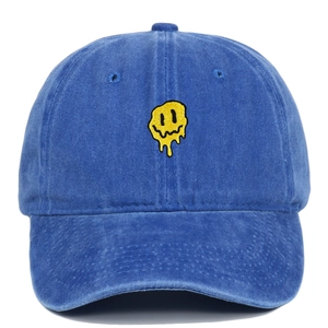 Détail de la broderie smiley jaune sur une casquette de baseball en coton bleu marine lavé