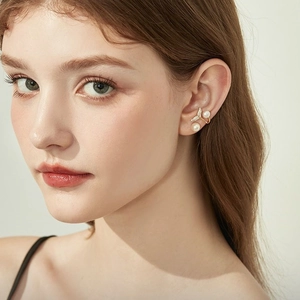 Exquisite gold mermaid tail earrings with sparkling pearls and diamonds worn by a model
