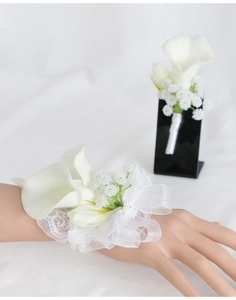 Detailed view of white calla lily corsage and wrist flower set with lace and ribbon