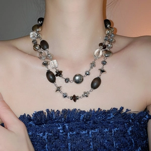 Close-up of double-layer beaded necklace featuring wood beads and crystals on a model
