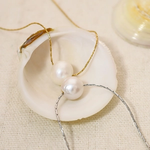 Colliers élégants en acier titane or et argent avec de grandes perles blanches dans un coquillage