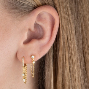 Detail of silver dangling star chain earrings with sparkling zircons on model