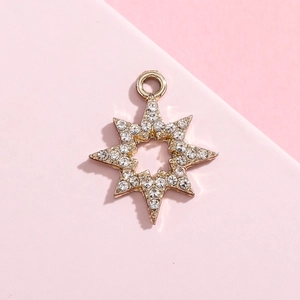 Detailed view of gold snowflake charm with cubic zirconia for jewelry making