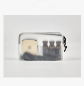 Macro shot of translucent frosted cosmetic bag showcasing interior makeup storage