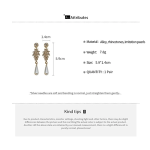 Detailed view of leaf drop pearl earrings with dimensions 5.9cm by 1.4cm and silver needles