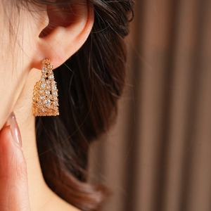 Dettaglio di orecchini placcati oro 18k a forma di U con zirconi indossati da una modella