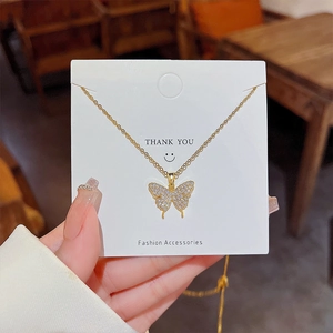Vue détaillée d'un pendentif papillon doré orné de zircons brillants sur une chaîne fine