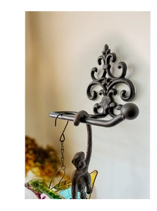 Close-up of vintage cast iron towel holder featuring a decorative fleur-de-lis carving
