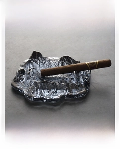 Macro shot of cigar rest on a Japanese style glacier glass ashtray with mountain texture