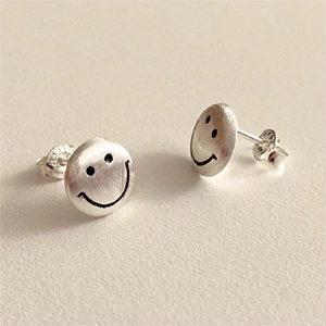 Detail view of 925 sterling silver smile earrings with a brushed matte texture finish
