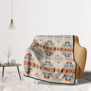 Detail of soft flannel throw blanket featuring Southwestern ethnic geometric patterns on sofa