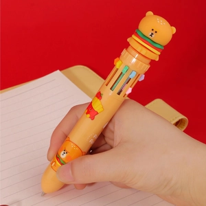 Close-up of yellow 6-color ballpoint pen with cartoon bear burger design in hand