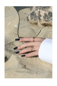Artistic golden S925 sterling silver rings with fluid texture on sandy beach background