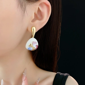Close-up of vintage floral earrings with colorful enamel and gold finish on model