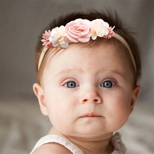 Close-up of pink and white fabric flower headband worn by a baby for photography