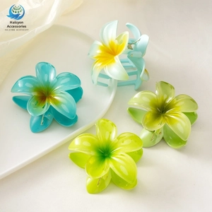 Detail of four gradient frangipani flower hair claws in blue and green resin matte finish