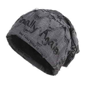 Distressed grey knit beanie with graffiti print and vintage torn details for street style