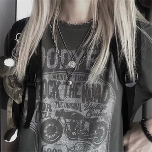Three-layer silver metal necklace with coin and ball pendants worn by a street style model