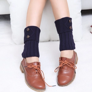 Detail of dark blue knit leg warmers with vintage buttons worn with leather shoes