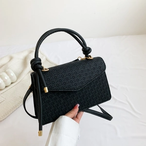 Chic black underarm bag with hexagonal woven pattern and gold hardware details