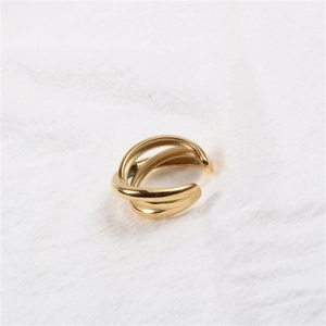 Detailed close-up of a golden multi-layer intertwined ring on white linen fabric