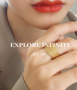 Detail view of gold layered geometric ring worn on finger with Explore Infinity text