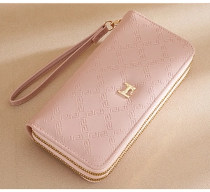 Cartera rosa con doble cremallera, textura geométrica en relieve y detalles metálicos dorados