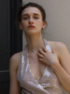 Close-up of 18K gold plated butterfly pendant necklace on a sequin dress model