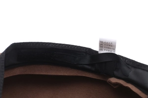 Detailed interior of wool beret showing sweatband, adjustable strap and care label