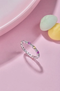 Detailed close-up of a silver band ring with colorful pink, purple, and yellow zircons