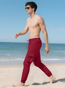Men's dark red cargo pants detail with drawstring waist and textured fabric on beach
