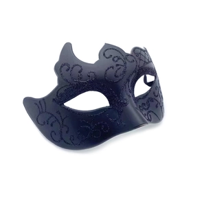 Macro view of black masquerade mask with matte finish and glitter scroll patterns