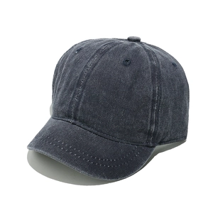 Detail view of washed cotton baseball cap with short brim and vintage navy blue texture