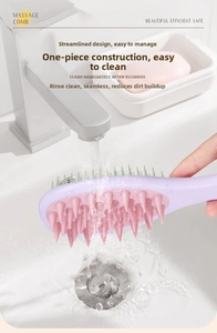 Detail of purple hair massage brush being rinsed under water for easy cleaning