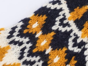 Macro shot of navy and mustard geometric jacquard knit pattern on a soft wool sweater