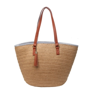 Minimalist woven straw tote bag with brown tassels and striped lining for beach vacations
