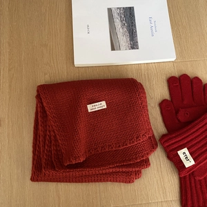 Primer plano de conjunto de bufanda y guantes rojos de punto grueso con etiquetas