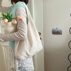 Detail showing white lace crochet shoulder bag with 3D floral embroidery textures