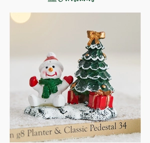 Miniature Christmas snowman scene with festive tree and gifts on snow base decor