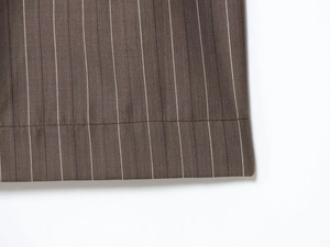 Gros plan sur tissu rayé marron montrant les coutures de l'ourlet et les détails du textile