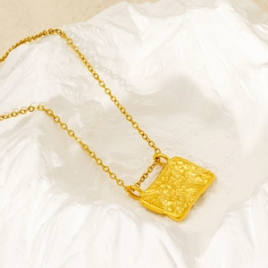 Macro shot of 18K gold plated square pendant with hammered texture and molten metal finish