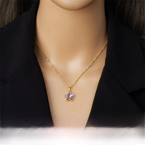 Detail view of the floral purple crystal pendant on a gold stainless steel necklace